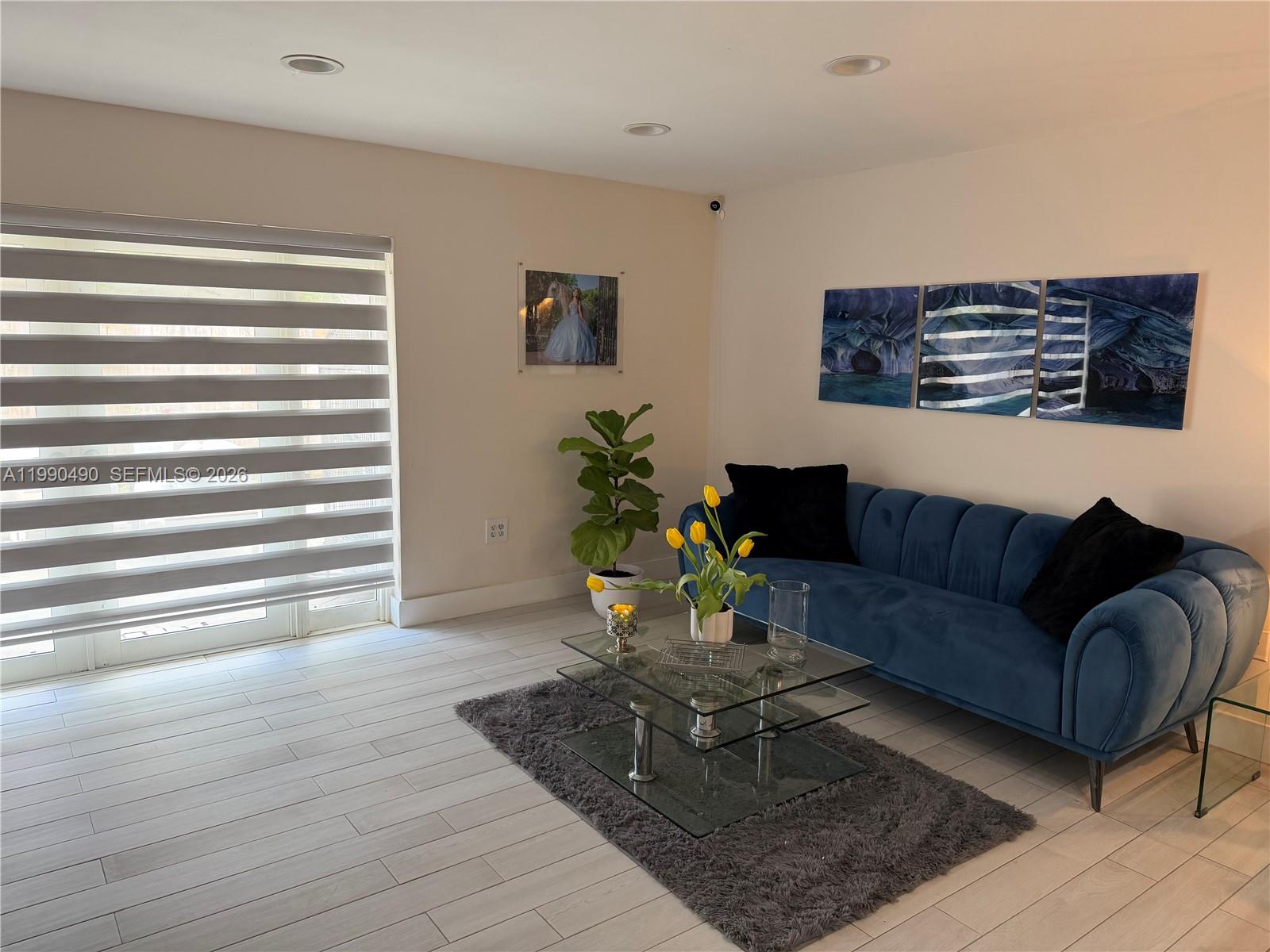 A living room features a blue velvet sofa, glass coffee table, and gray area rug — 7431 SW 163rd Pl, Miami FL 33193, MIAMI, FL