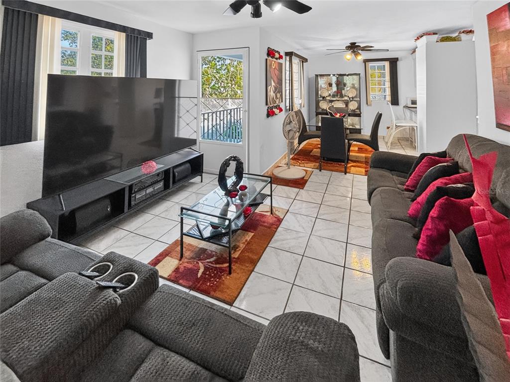 A living room with tile floors, a large television, and an adjacent dining area — SOLAR S4 BO HIGUILLAR UNIT PARCELA #28, DORADO, PR