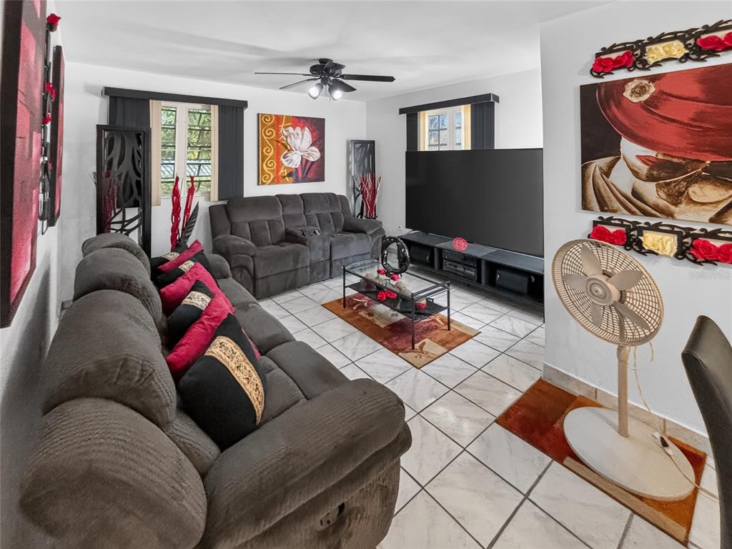 A living room features gray reclining sofas, a large television, and white tiled floors — SOLAR S4 BO HIGUILLAR UNIT PARCELA #28, DORADO, PR
