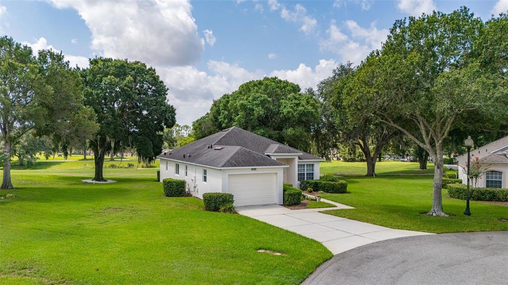 A single-story house with a white exterior, a garage, and a driveway sits on grass — 3604 KINGSWOOD COURT, CLERMONT, FL