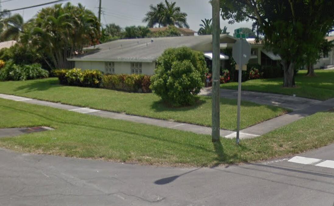 A single-story house with a lawn, driveway, and landscaping sits on a corner lot — 712 NE 23rd Terrace, Pompano Beach FL 33062, POMPANO BEACH, FL