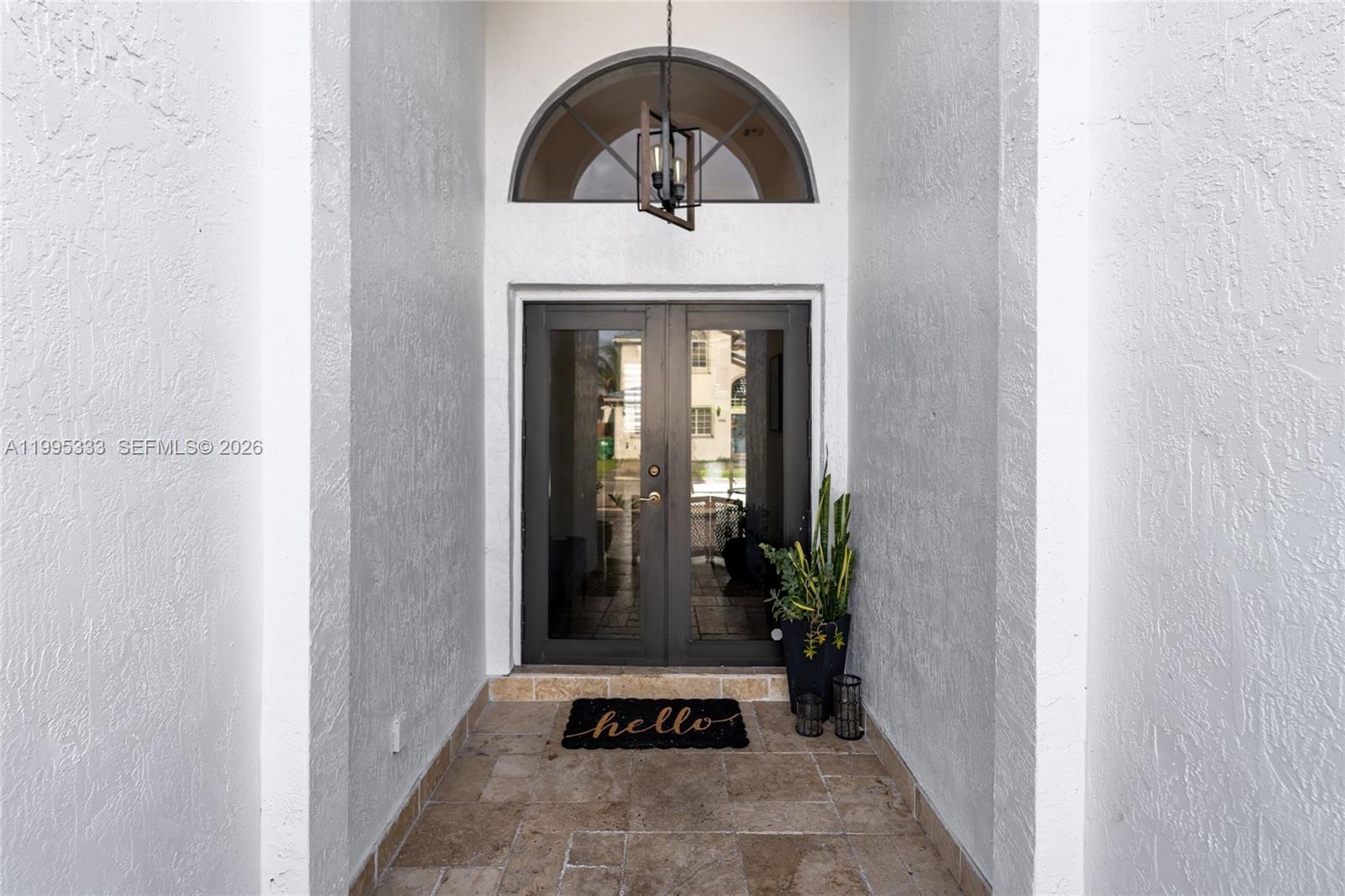 A front entryway features double glass doors, a stone floor, and an arched transom window — 3551 SW 152nd Pass, Miami FL 33185, MIAMI, FL