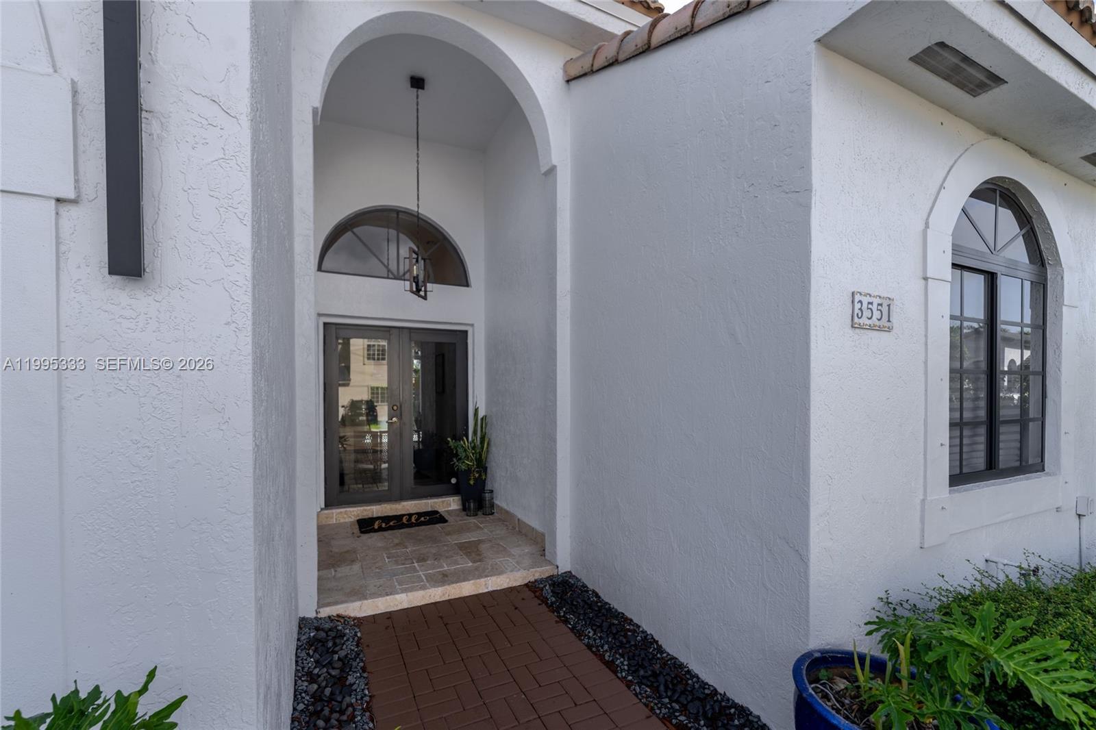 The exterior entrance features a white stucco facade, an arched doorway, and a brick walkway — 3551 SW 152nd Pass, Miami FL 33185, MIAMI, FL