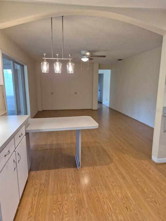 A kitchen with a breakfast bar and dining area featuring wood-look flooring and a chandelier — 39 PINE VALLEY CIRCLE, ORMOND BEACH, FL