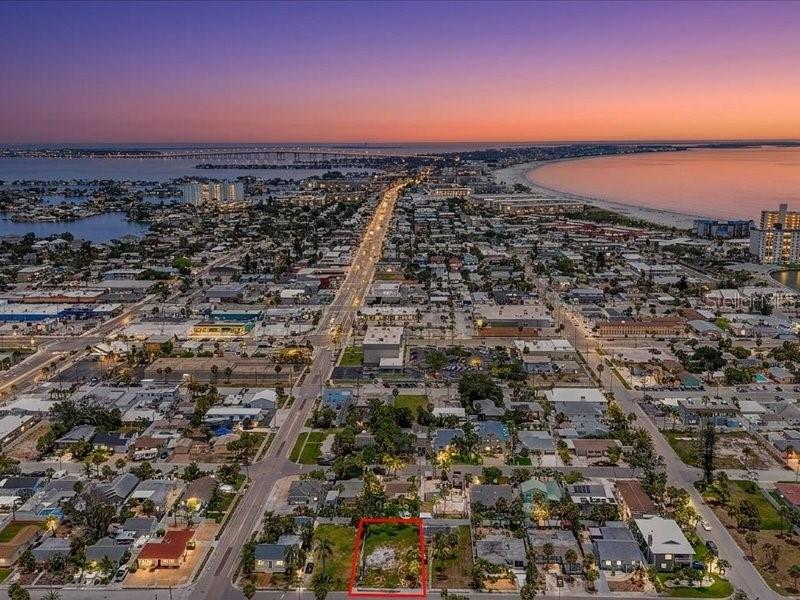 An aerial view shows a vacant rectangular lot outlined in red within a coastal neighborhood — 516 78TH AVENUE, ST PETE BEACH, FL