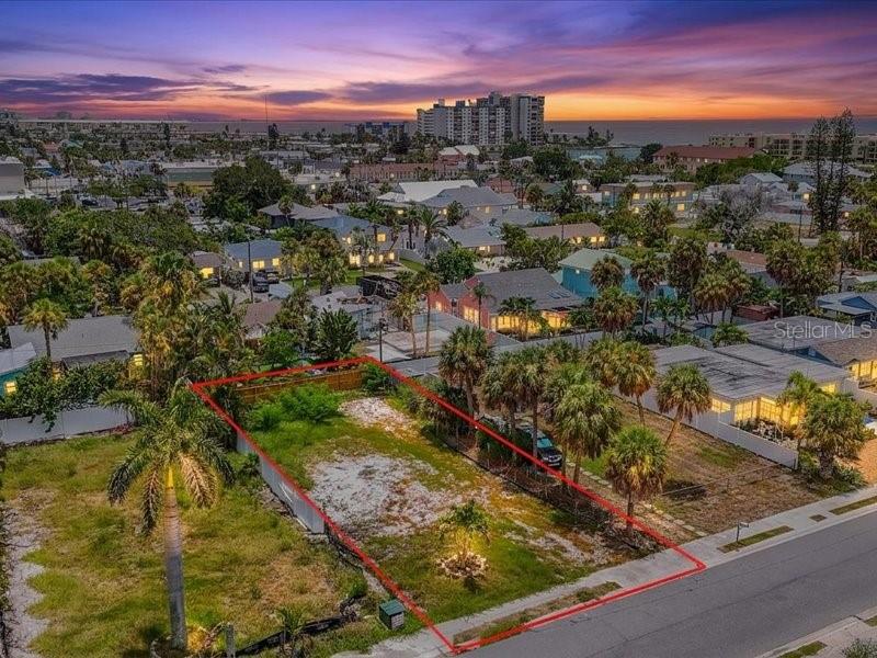 An aerial view shows a vacant, rectangular residential lot outlined in red along a street — 516 78TH AVENUE, ST PETE BEACH, FL