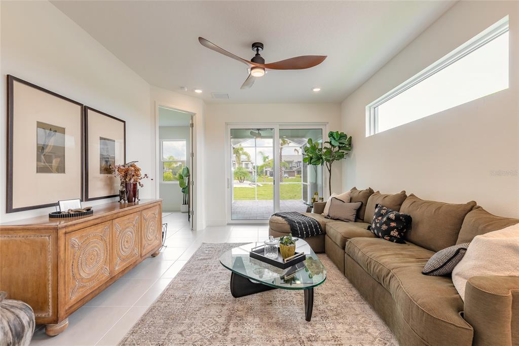 A living room features a brown sectional sofa, a glass coffee table, and a wooden sideboard — 3038 ISLES WAY, NEW SMYRNA BEACH, FL