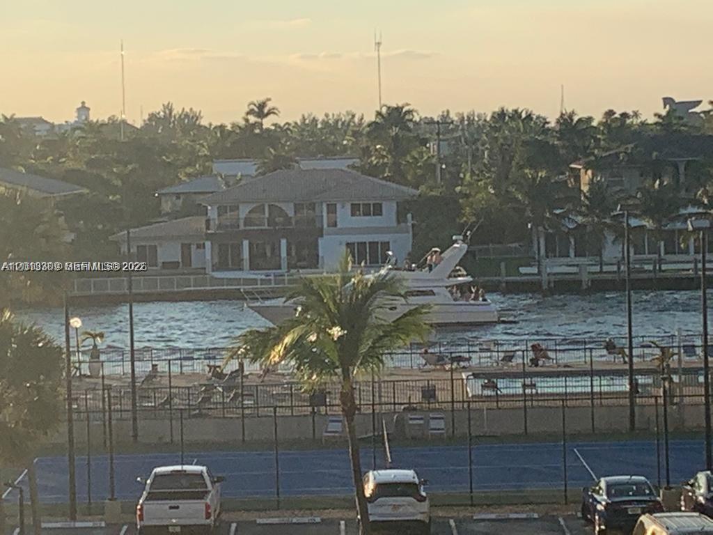 A view of a canal with a boat, a swimming pool, and a tennis court — 2049 S Ocean Dr, Hallandale Beach FL 33009, HALLANDALE BEACH, FL
