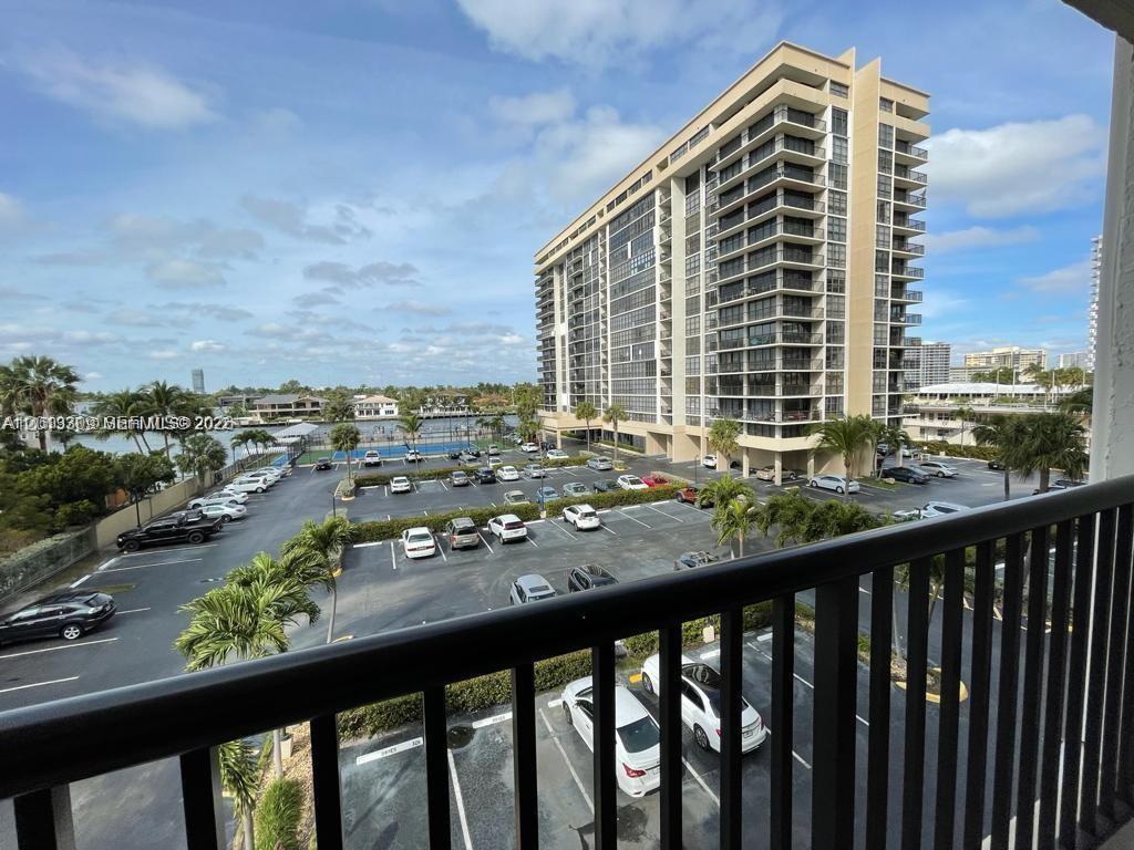 A high-angle view from a balcony overlooks a parking lot and a tall apartment building — 2049 S Ocean Dr, Hallandale Beach FL 33009, HALLANDALE BEACH, FL