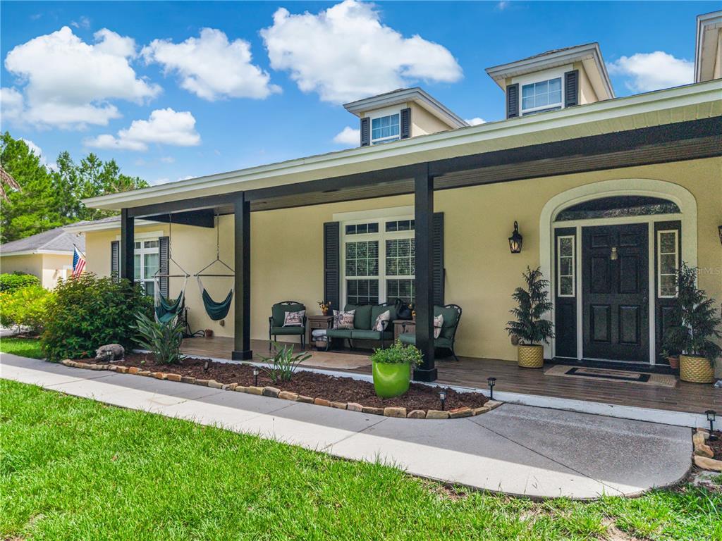 A single-story house with a covered front porch, black columns, and a dark front door — 450 VALLEY STREAM DRIVE, GENEVA, FL
