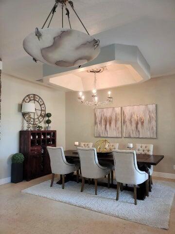 A dining room features a dark wood table, upholstered chairs, and two distinct hanging light fixtures — 5574 55th Avenue, Vero Beach FL 32967, VERO BEACH, FL