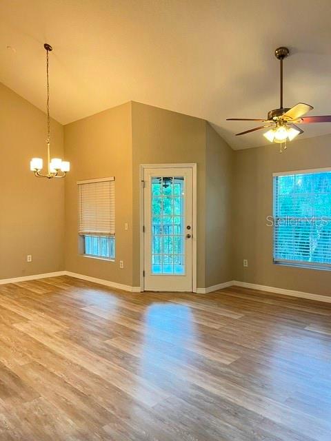 An interior room features light wood-look flooring, a ceiling fan, a chandelier, and a glass-paneled door — 970 N SPRING GARDEN AVENUE UNIT 122, DELAND, FL