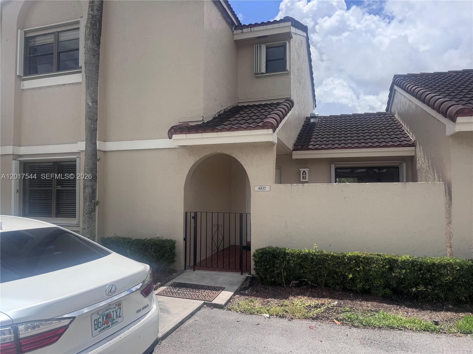 A galley kitchen features white cabinets, stainless steel appliances, a stacked washer-dryer, and light flooring — 6532 NW 170th Ter, Hialeah FL 33015, HIALEAH, FL