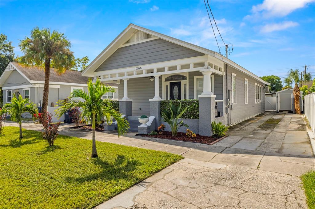 A grey, single-story bungalow with a front porch, palm trees, and a concrete driveway — 2526 W UNION STREET, TAMPA, FL