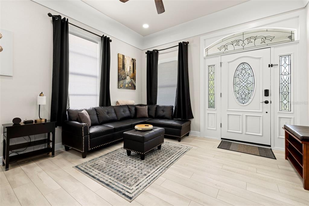 A living room features a black sectional sofa, a patterned area rug, and a front door — 2526 W UNION STREET, TAMPA, FL