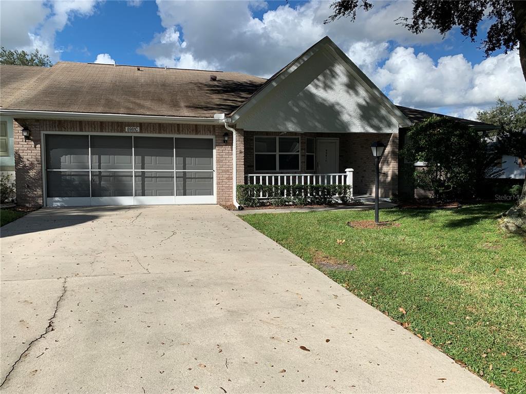 A single-story brick house with a screened garage door and a front porch — 8981 SW 95TH STREET UNIT C, OCALA, FL