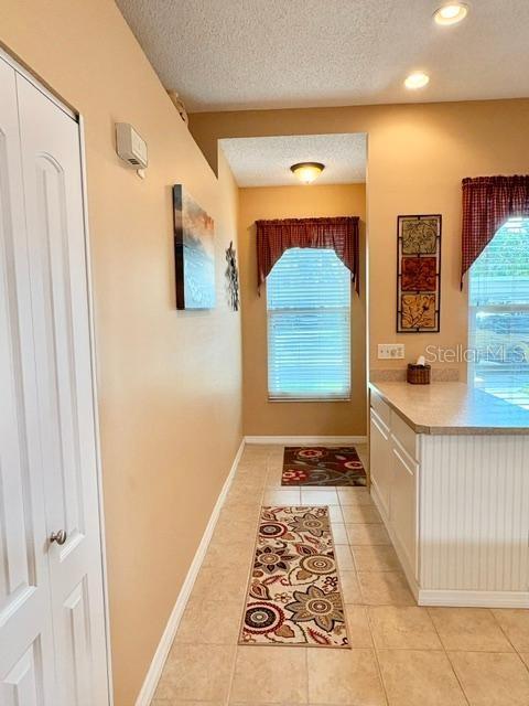 A kitchen features white cabinets, a breakfast bar, and a dining area with two windows — 311 KELSEY WAY UNIT 3, SUN CITY CENTER, FL