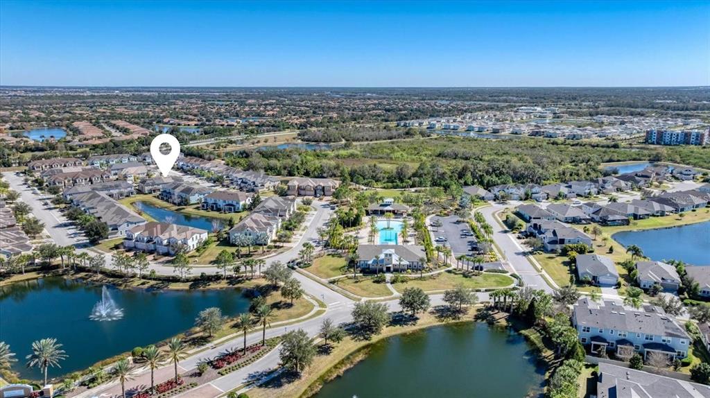 An aerial view shows a residential community with multiple buildings, ponds, and a central clubhouse — 5038 SUNNYSIDE LANE, BRADENTON, FL