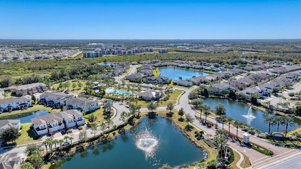 An aerial view shows a residential community with multiple ponds, fountains, and a swimming pool — 5038 SUNNYSIDE LANE, BRADENTON, FL