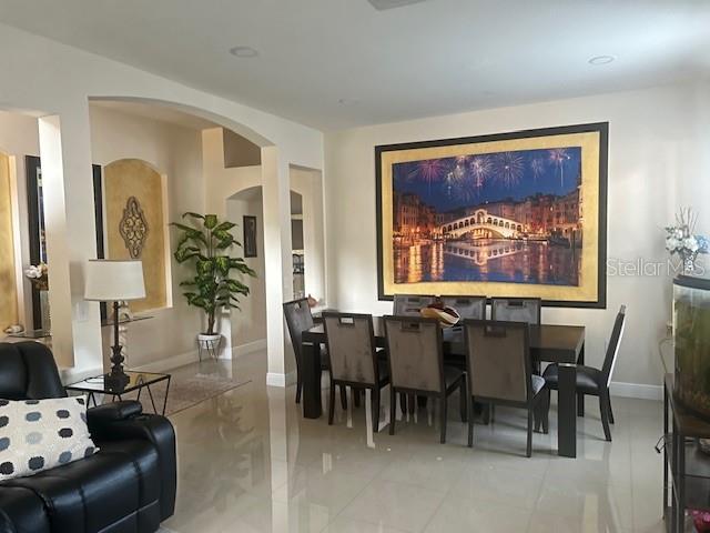 A dining room features a large framed landscape painting above a table with six chairs — 34809 PRAIRIE RIDGE WAY, ZEPHYRHILLS, FL