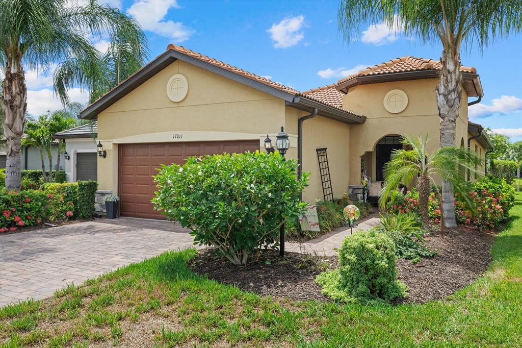 A tan stucco house with a brown garage door and a tiled roof — 17011 HAMPTON FALLS TERRACE, LAKEWOOD RANCH, FL