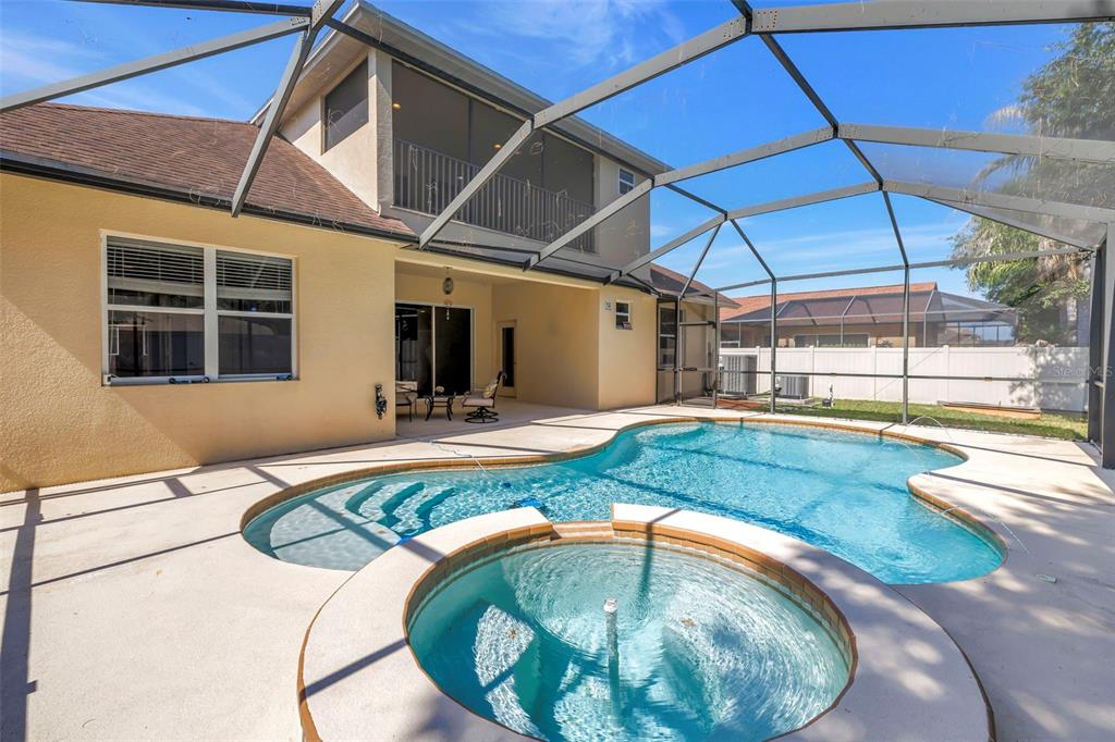 A laundry room features white appliances, open shelving, wall art, and a hanging basket — 27405 SORA BOULEVARD, WESLEY CHAPEL, FL