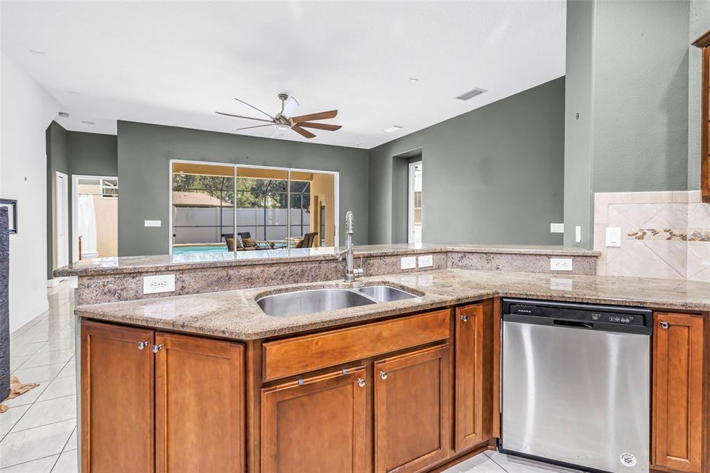 A backyard swimming pool and hot tub enclosed by a screened lanai behind a house — 27405 SORA BOULEVARD, WESLEY CHAPEL, FL
