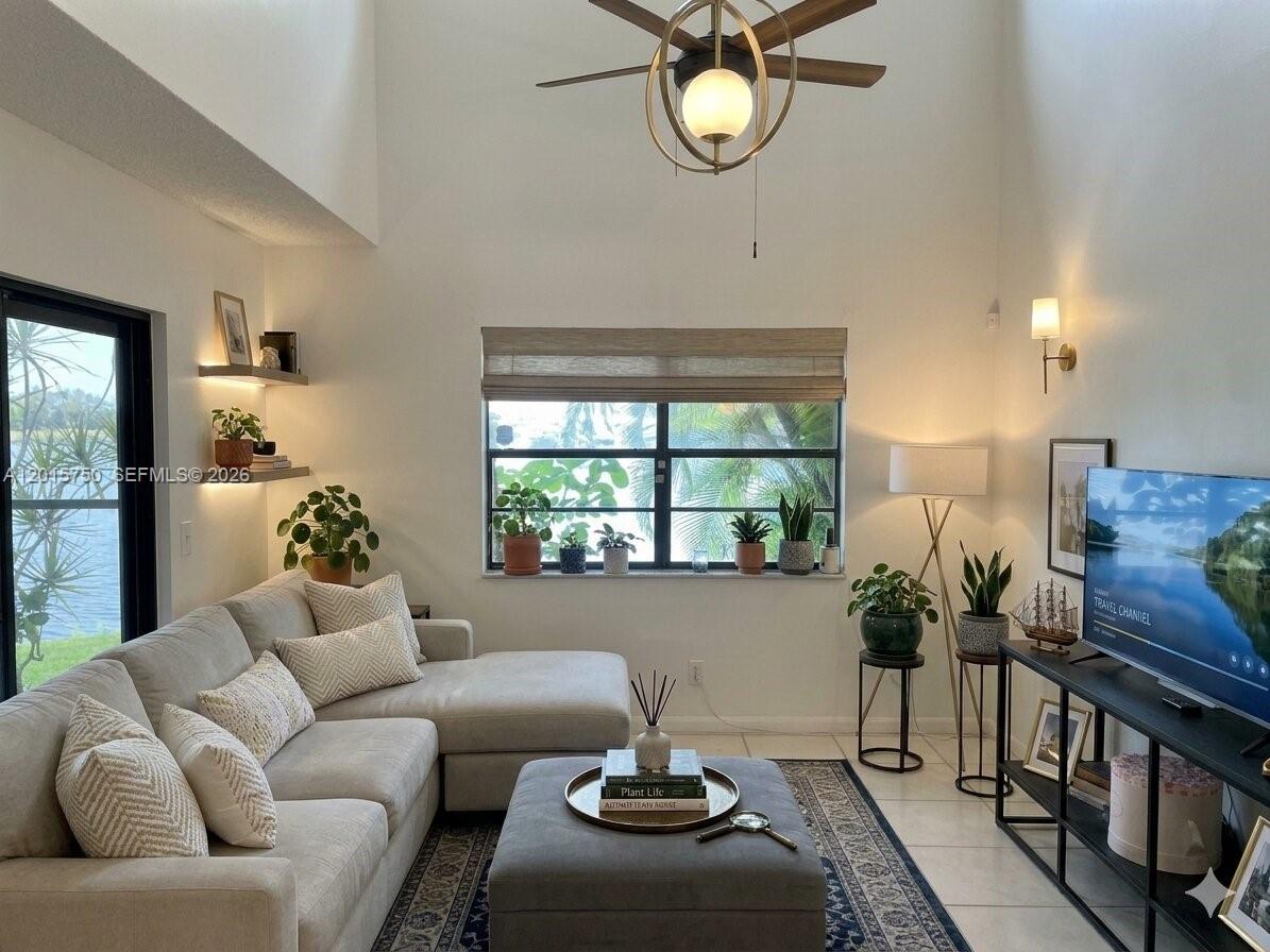 A living room features a sectional sofa, a central ottoman, and a large window — 341 Ives Dairy Rd # 06, Miami FL 33179, MIAMI, FL