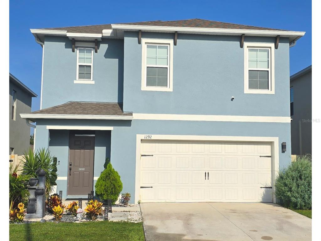 A two-story blue house with a two-car garage and a front entrance — 1292 CASCADES AVENUE, DAVENPORT, FL