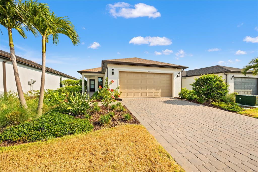 A single-story house with a paved driveway, a two-car garage, and palm trees — 6600 SILVERSTAR DRIVE, SARASOTA, FL