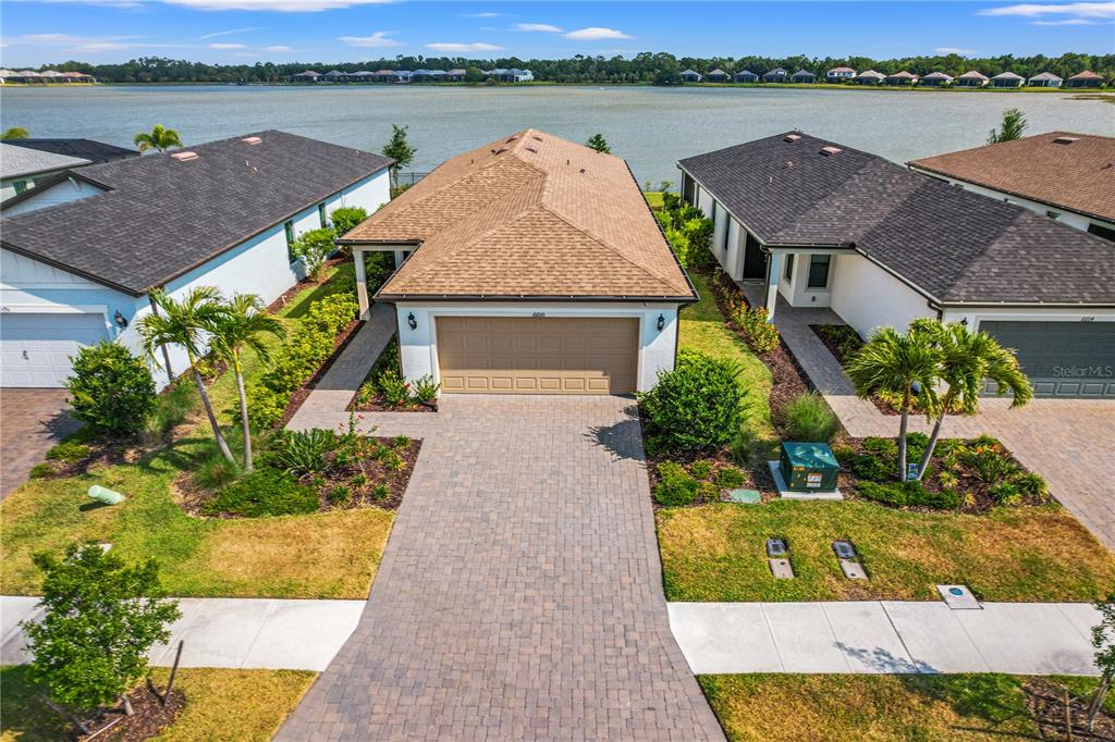 An aerial view shows a suburban house with a tan roof and paved driveway — 6600 SILVERSTAR DRIVE, SARASOTA, FL