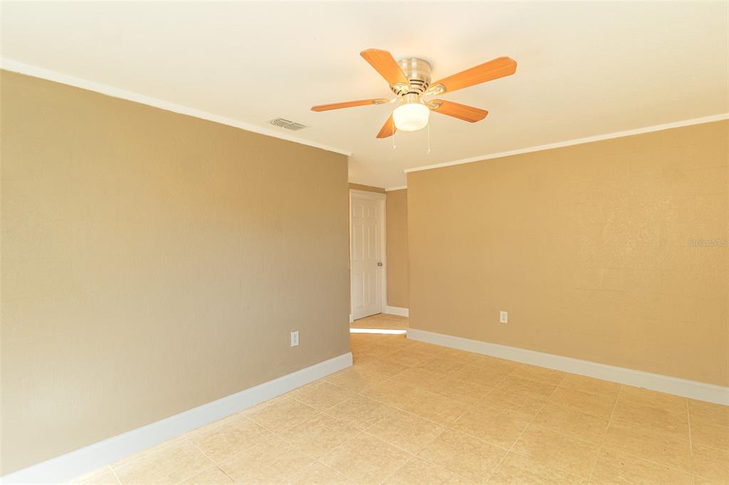 A room with tan walls, light-colored tile flooring, and a ceiling fan — 114 E NORTHSIDE DRIVE UNIT 3, LAKE WALES, FL