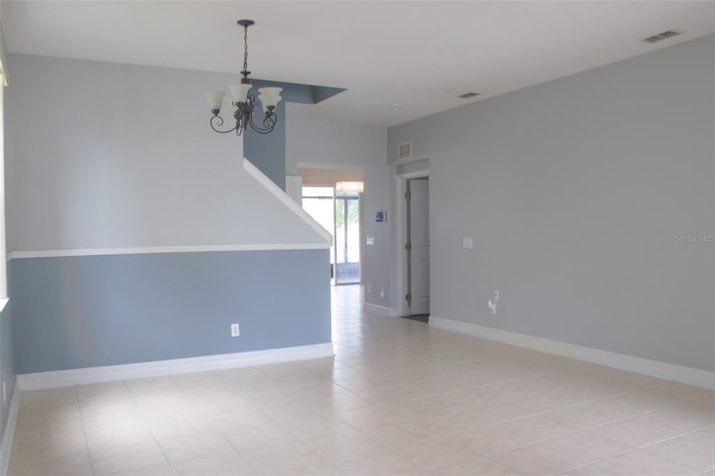 An interior view shows a dining area with a chandelier, tile flooring, and two-toned walls — 1338 BLACKWATER POND DRIVE, ORLANDO, FL