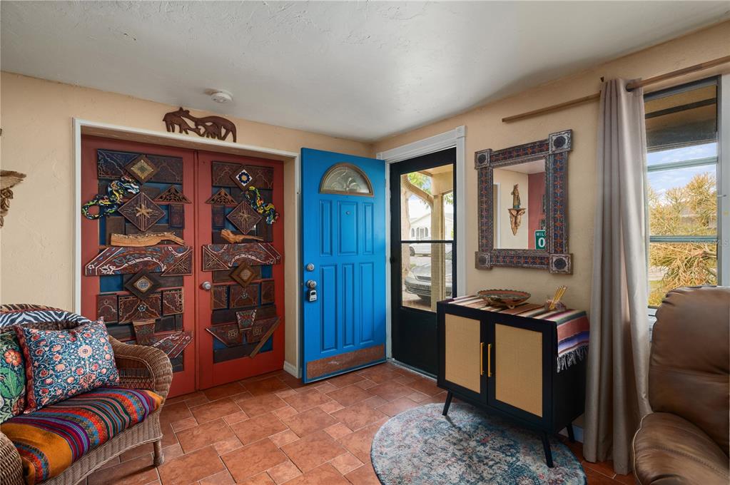 An entryway features a blue front door, terracotta tile floors, and a decorative wall display — 611 BONITA COURT, PUNTA GORDA, FL