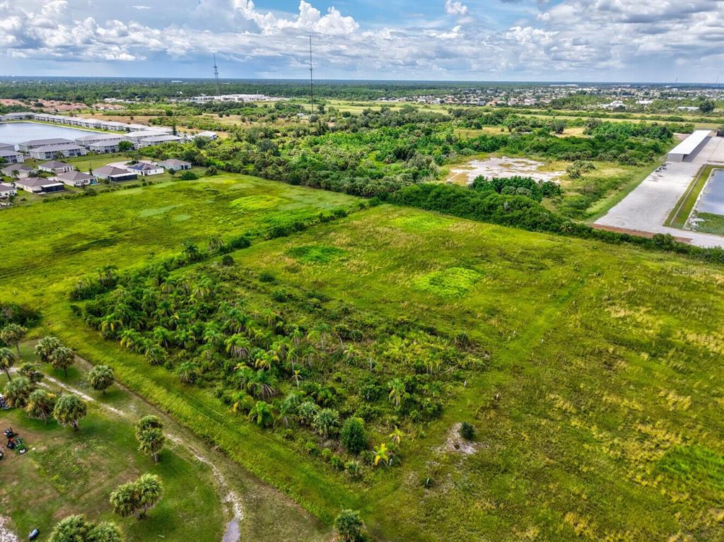 An aerial view shows a large, grassy, undeveloped lot with scattered palm trees and vegetation — 3100 ROWLAND DRIVE UNIT Tract B, PUNTA GORDA, FL