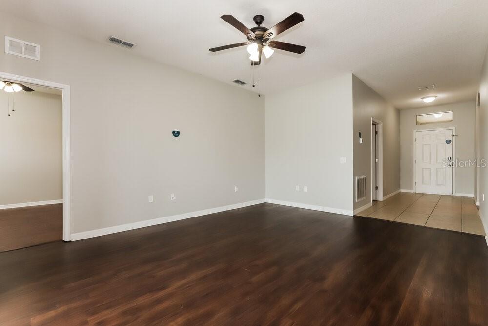 An empty living room features dark wood flooring, light gray walls, and a ceiling fan — 925 KRENSON WOODS ROAD, LAKELAND, FL