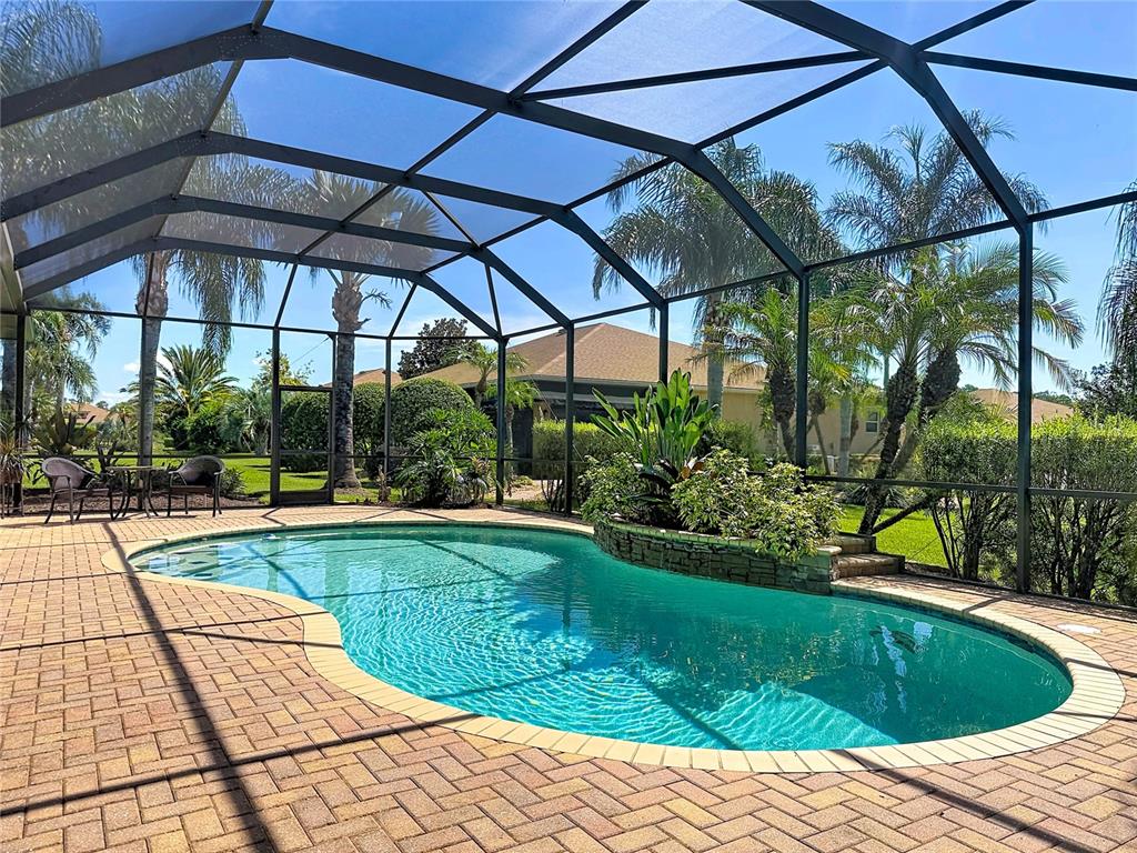 A screened-in swimming pool with a stone-accented planter and brick paver deck — 4231 COCONUT DRIVE, LAKE WALES, FL