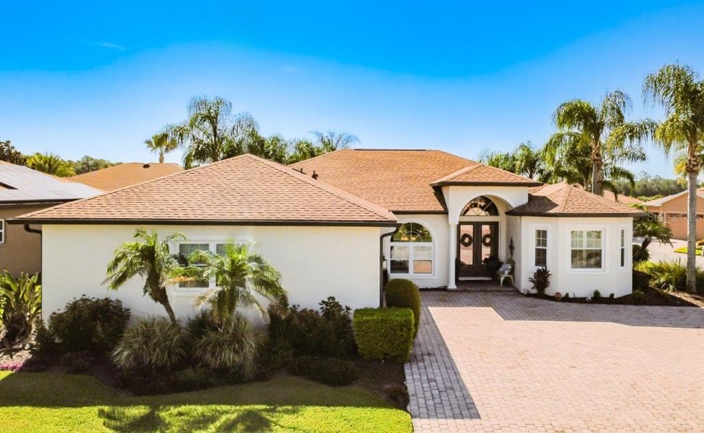 A single-story house with a paved driveway, palm trees, and a tan shingled roof — 4231 COCONUT DRIVE, LAKE WALES, FL