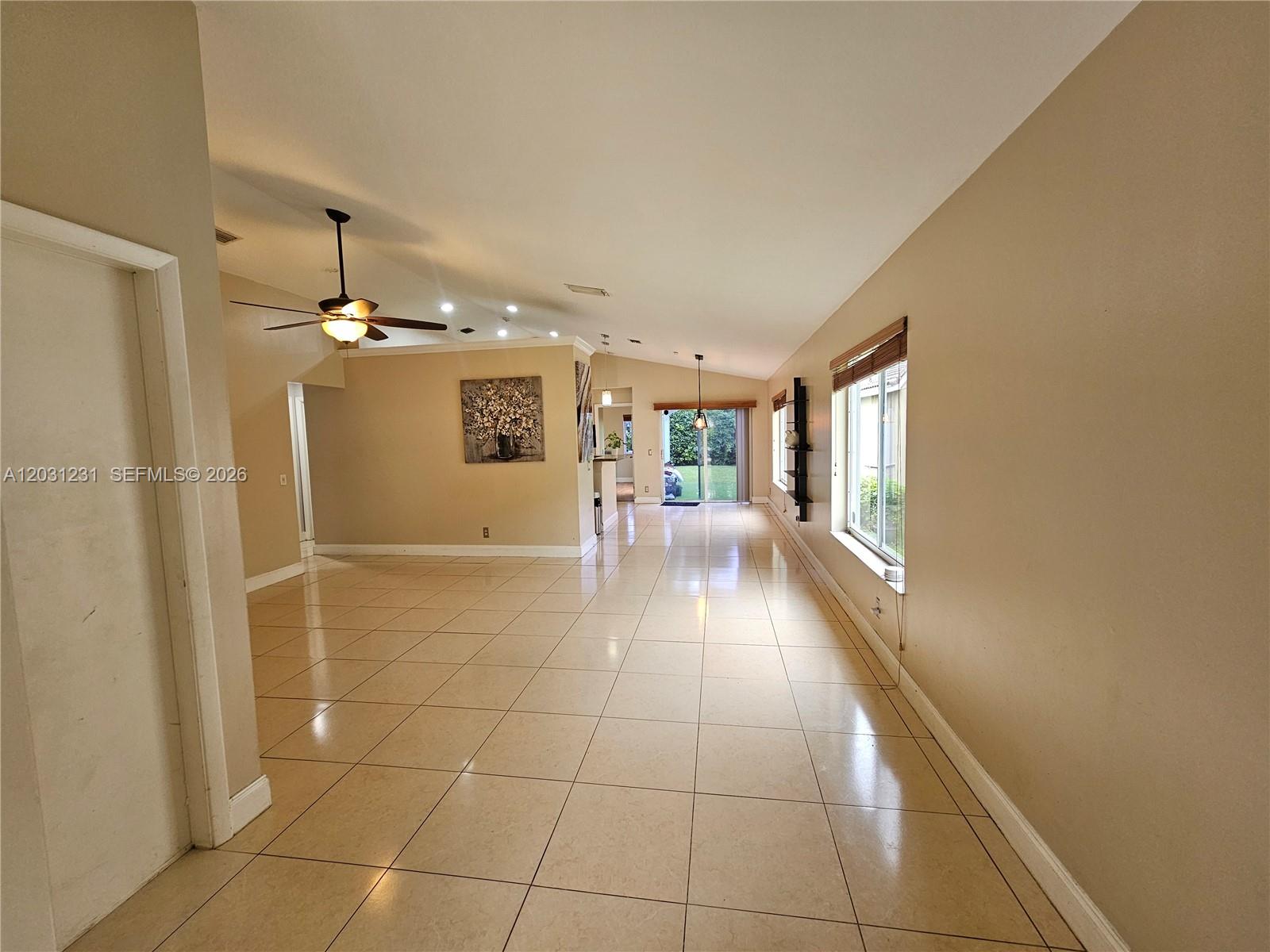 A spacious living area features beige tile flooring, a vaulted ceiling, and a sliding glass door — 4232 Mahogany Ridge Dr, Weston FL 33331, WESTON, FL