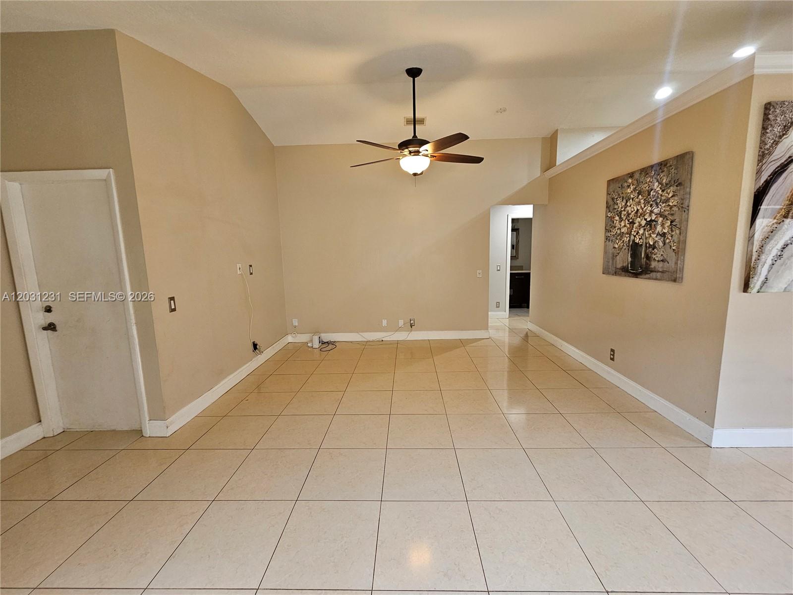 A spacious room features beige tile flooring, tan walls, a ceiling fan, and a doorway — 4232 Mahogany Ridge Dr, Weston FL 33331, WESTON, FL