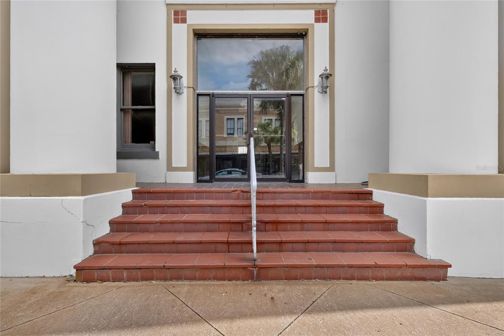 A set of red tiled steps leads to a glass double door entrance — 400 W MAIN STREET, LEESBURG, FL