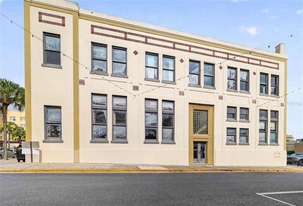 A three-story commercial building with a tan facade and multiple rectangular windows — 400 W MAIN STREET, LEESBURG, FL