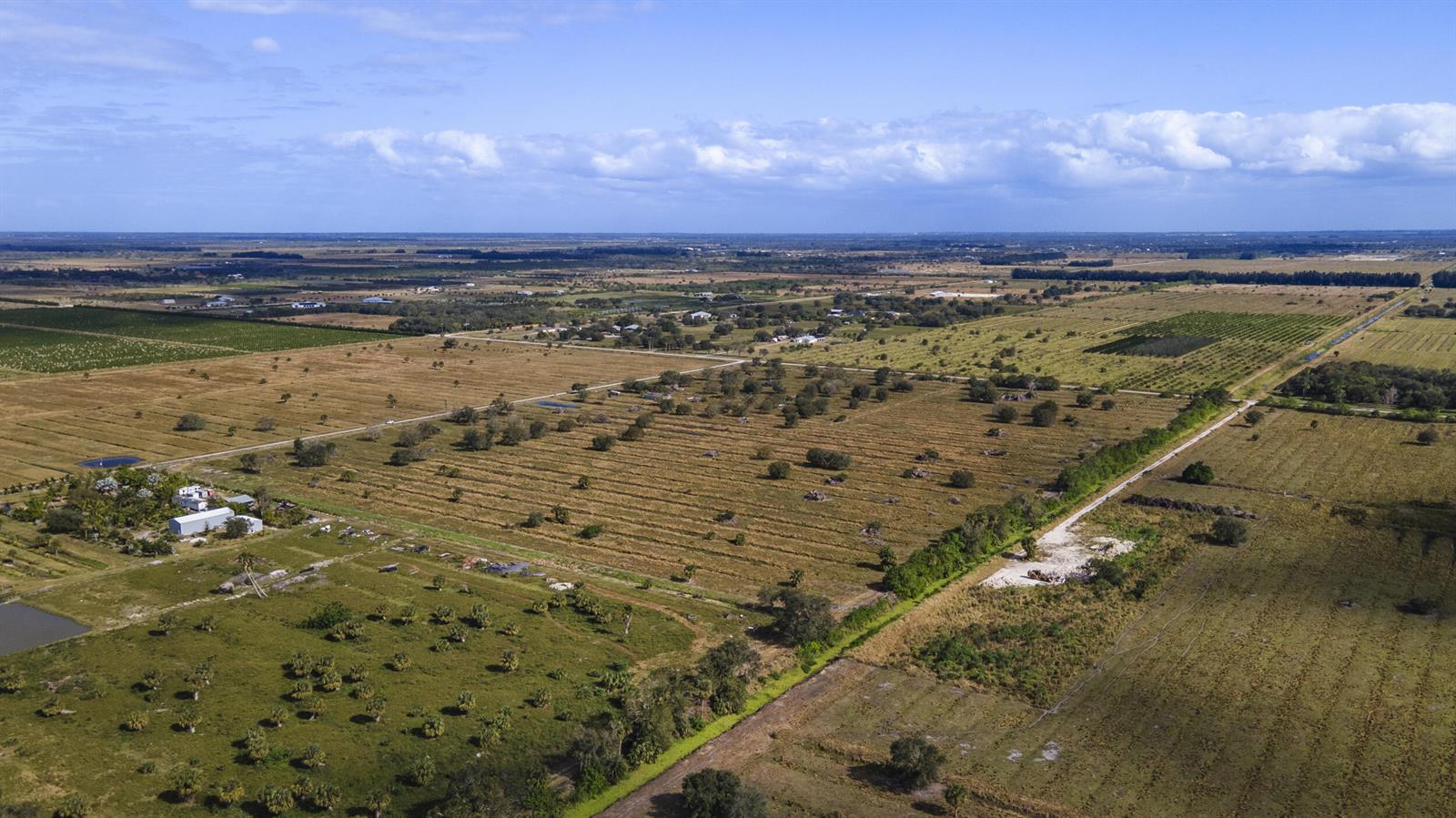 An aerial view of a large, flat, rural landscape with scattered trees and dirt roads — 2321 Sneed Road, Fort Pierce FL 34945, FORT PIERCE, FL