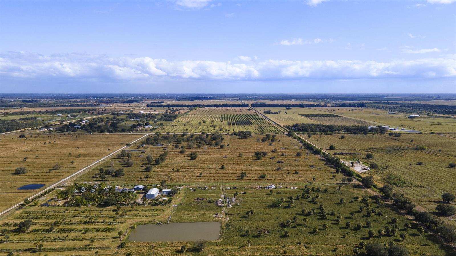 An aerial view shows a large rural property with fields, a pond, and several buildings — 2321 Sneed Road, Fort Pierce FL 34945, FORT PIERCE, FL