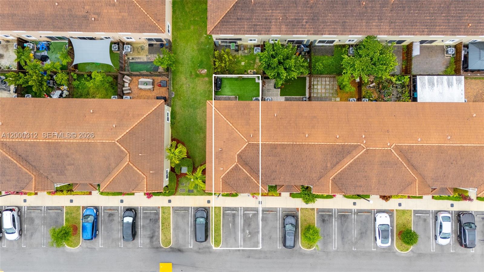 An aerial view shows a townhouse unit with a backyard and assigned parking spaces — 2440 SE 10th Ct, Homestead FL 33035, HOMESTEAD, FL