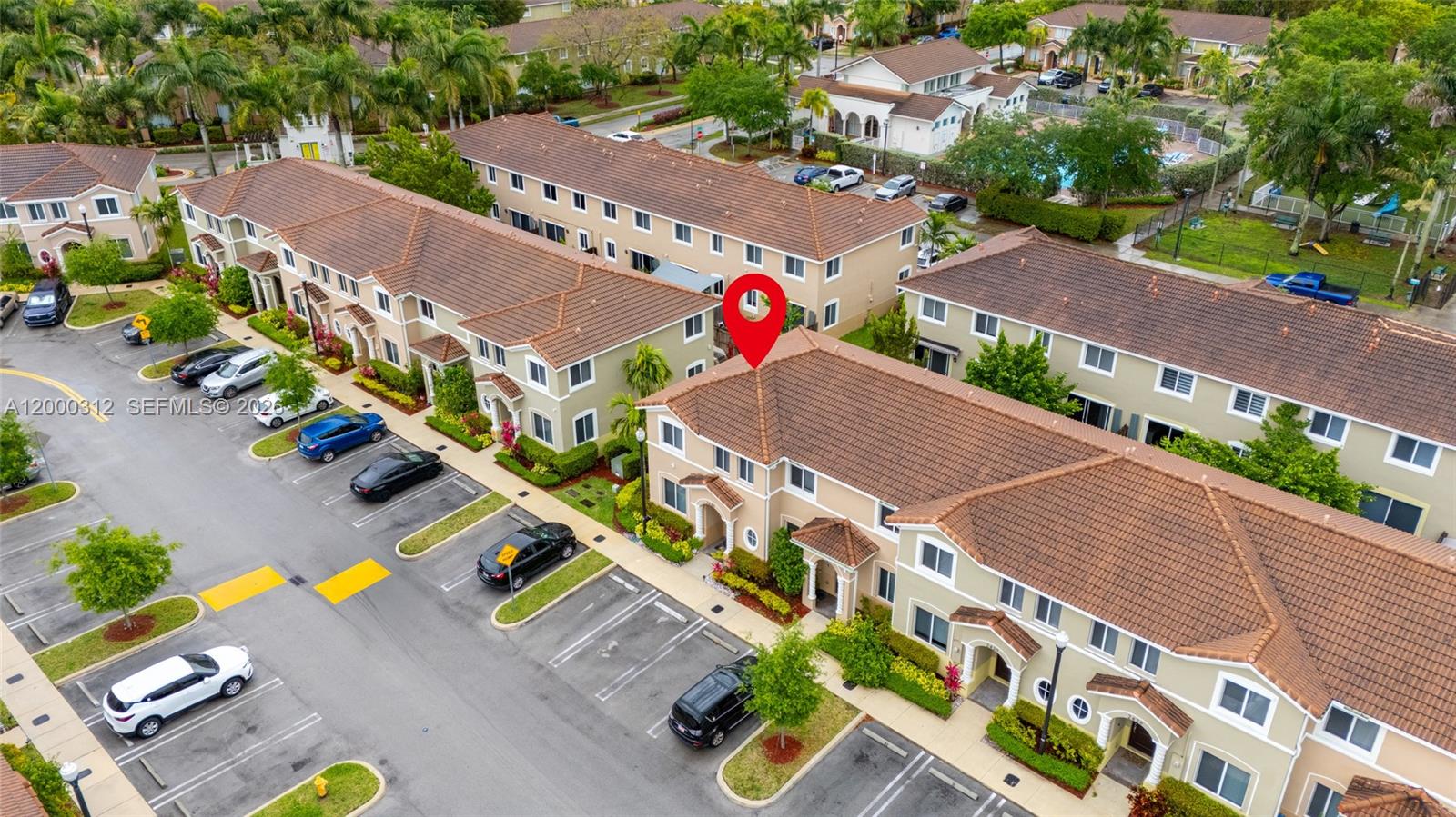 An aerial view shows a multi-story residential townhouse complex with parking spaces and landscaping — 2440 SE 10th Ct, Homestead FL 33035, HOMESTEAD, FL