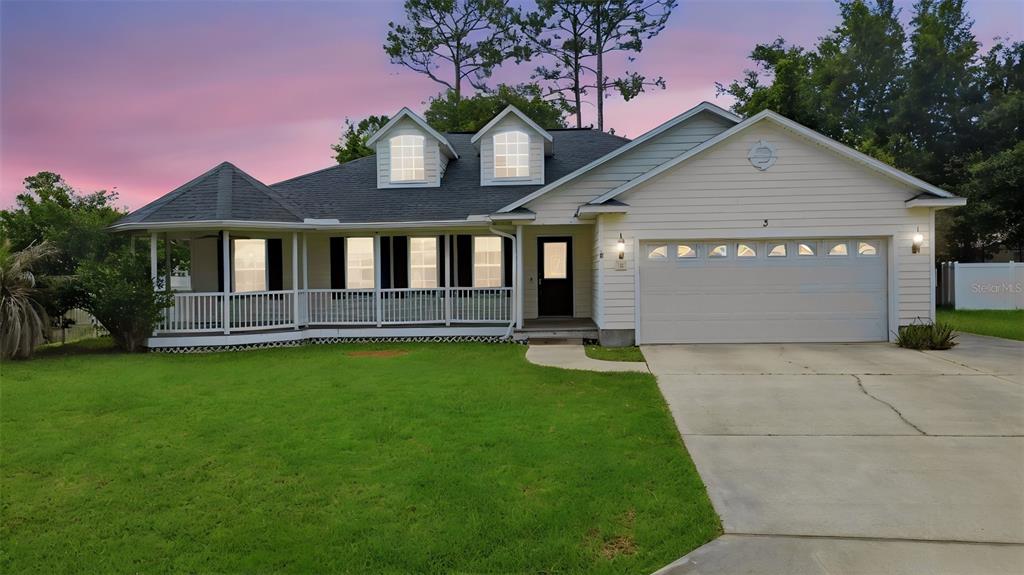 A single-story house with a white exterior, a front porch, two dormer windows, and a garage — 3 EASTGATE LANE, PALM COAST, FL