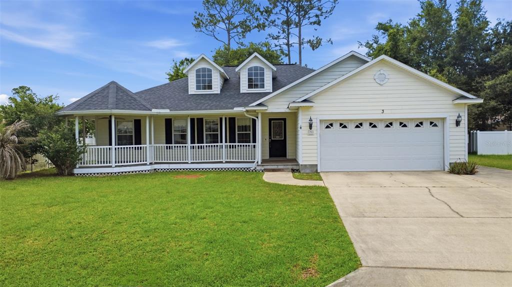 A one-story house with light siding, a front porch, two dormer windows, and a garage — 3 EASTGATE LANE, PALM COAST, FL