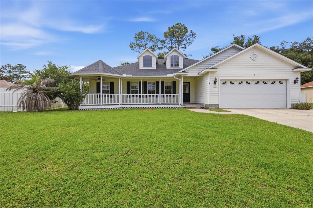 A single-story house with white siding, a front porch, two dormers, and an attached garage — 3 EASTGATE LANE, PALM COAST, FL
