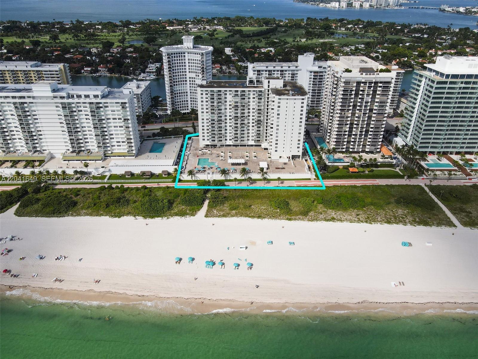 An aerial view shows a high-rise residential building with a pool deck facing the beach — 5701 Collins Ave # 619, Miami Beach FL 33140, MIAMI BEACH, FL